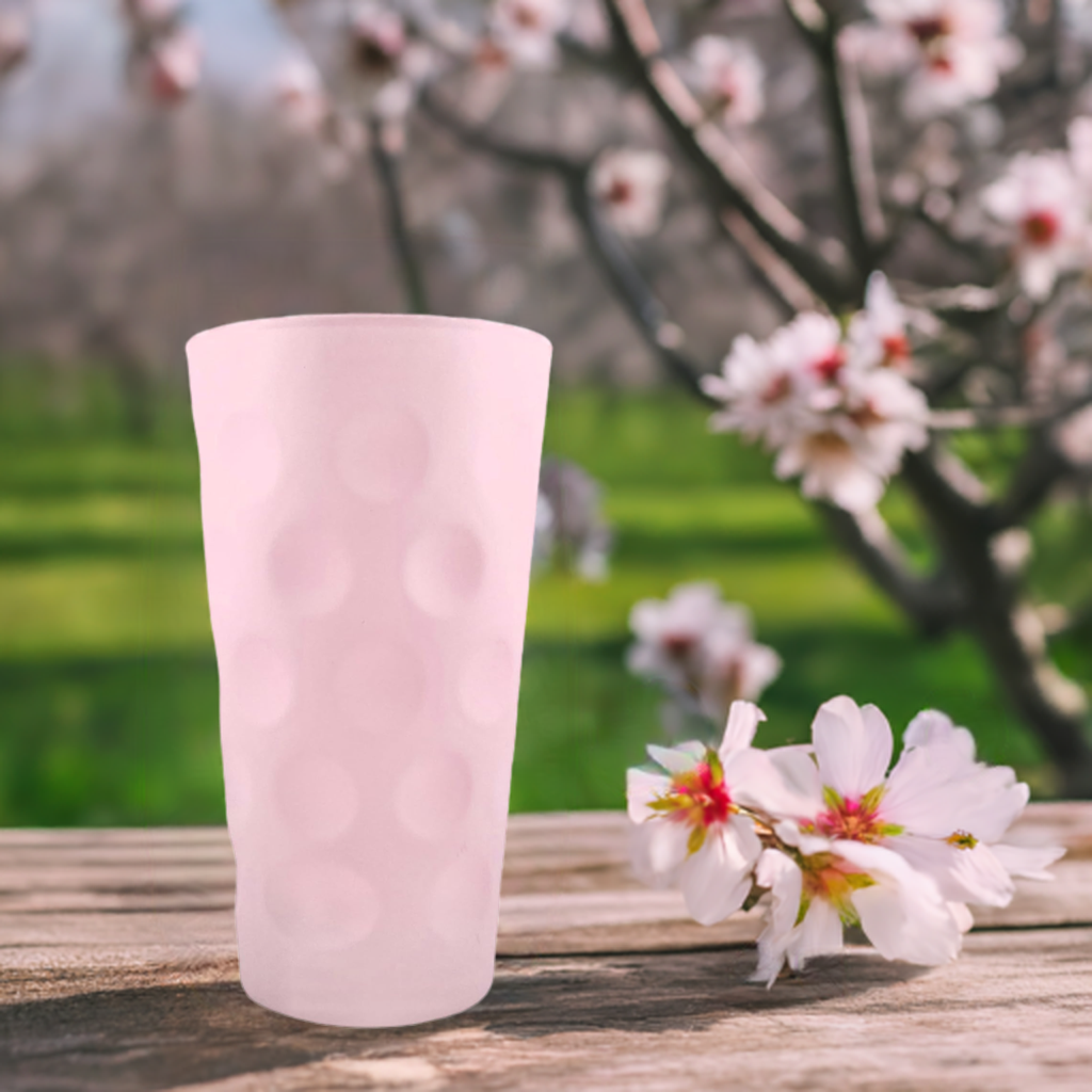 Rosa matt farbiges Dubbeglas 0,5 L und blühende Mandelbäume