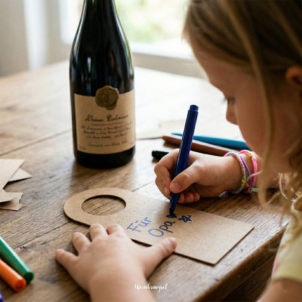 Ein Kind beschriftet den Flaschenanhänger als Geschenk für den Opa.