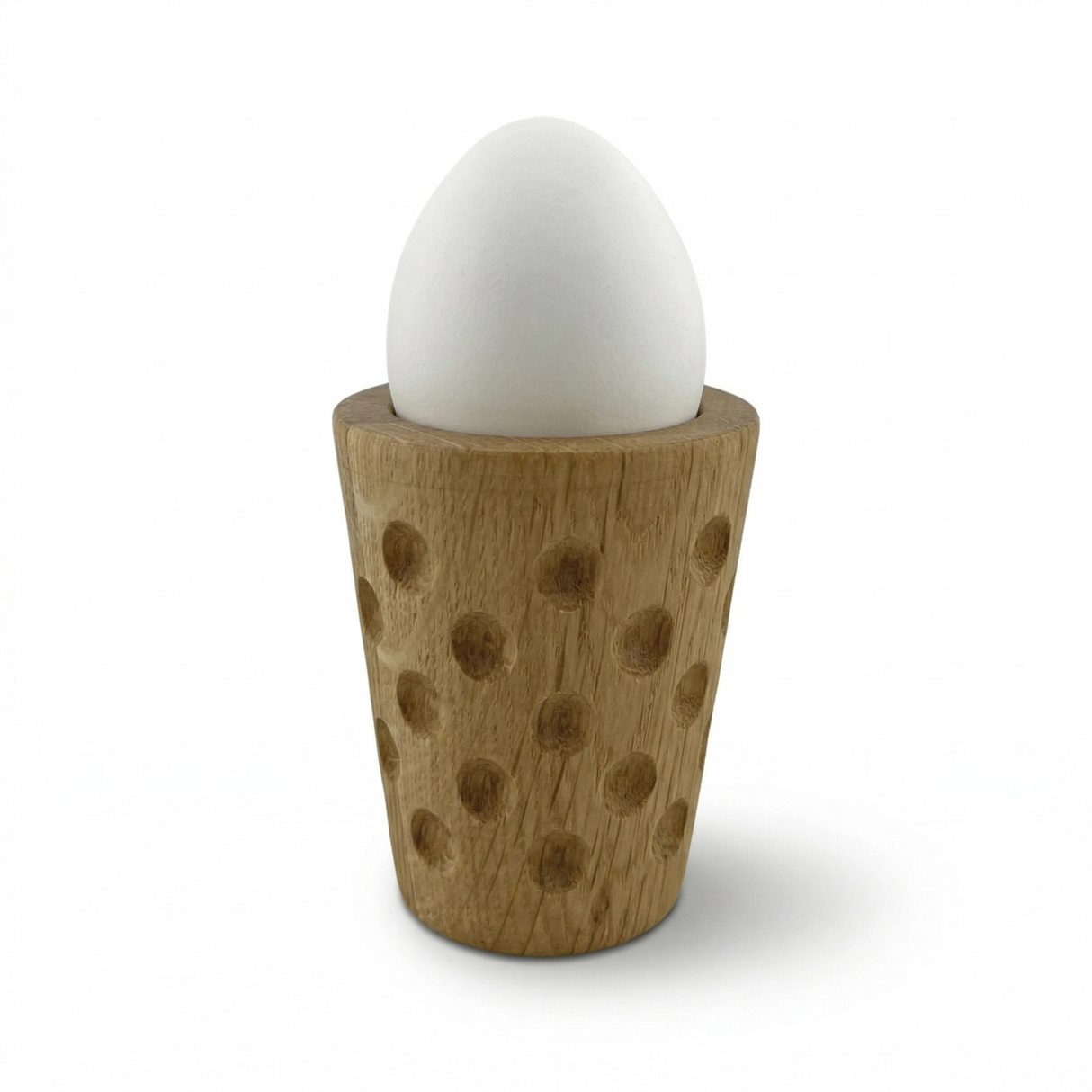 Der Dubbe Eierbecher aus Eichenholz hat rundum Dubbe wie ein Dubbeglas.