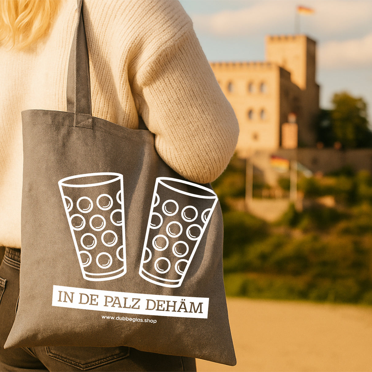 In de Palz dehäm & Dubbegläser Baumwolltasche, Pfälzerin mit Tasche vor dem Hambacher Schloss