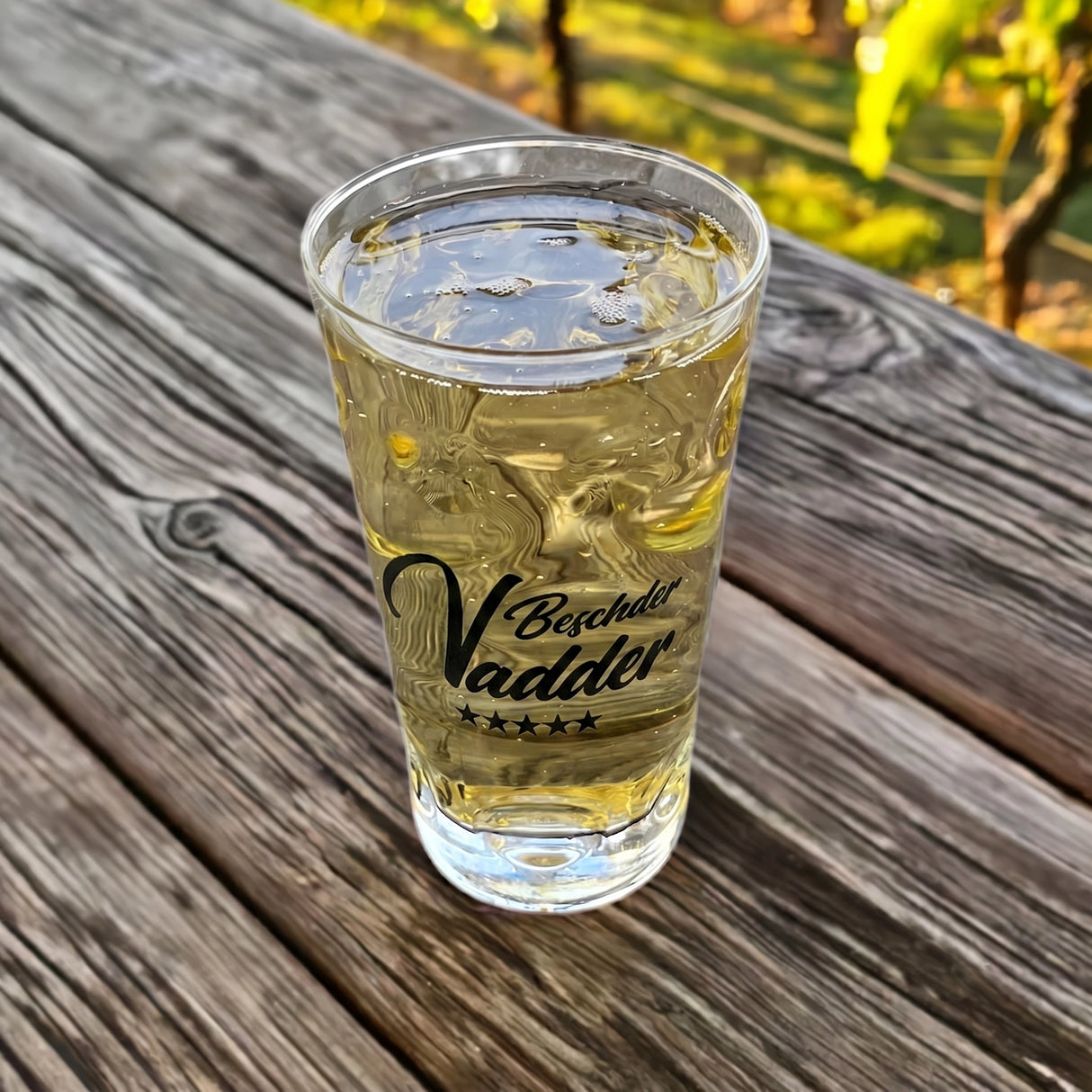 Bester Vater Dubbeglas 0,5 L, mit Rieslingschorle auf einem alten Holztisch