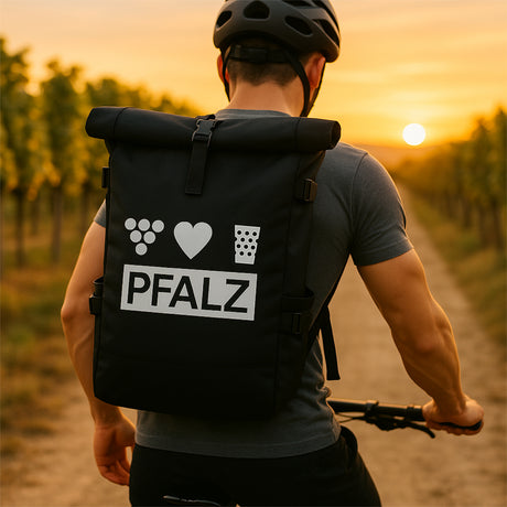 Pfalz Rolltop Rucksack,  Schwarz, mit einem Pfälzer auf einem Fahrrad in den Weinbergen